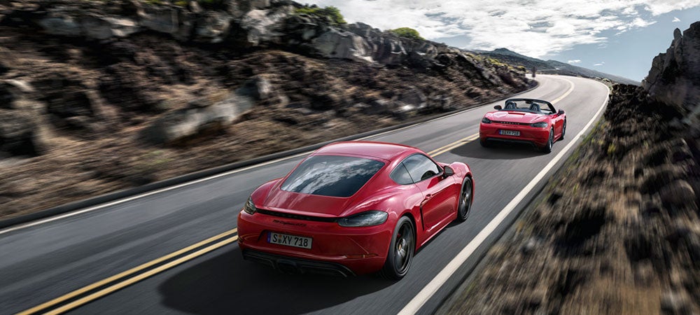 Porsche Cayman driving down mountain highway